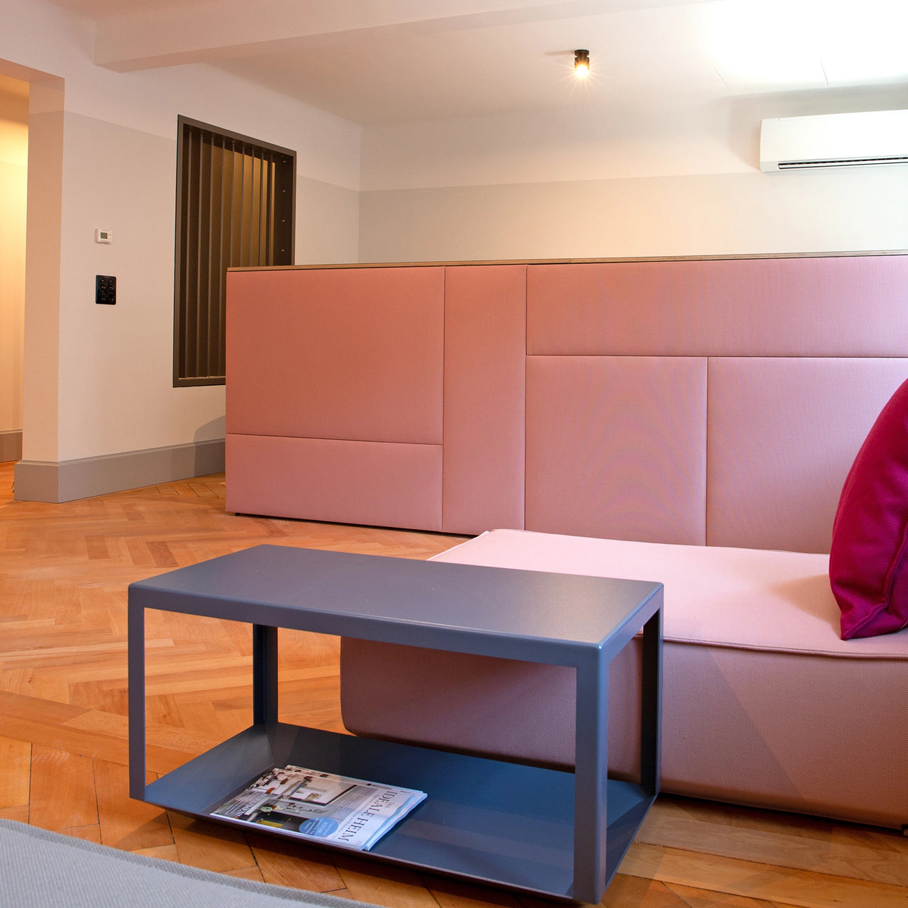 Einrichtungssituation im Cubit Lookroom Zürich mit rosa Sofamodulen, Beistelltisch und Wandverkleidung aus gepolsterten Paneelen