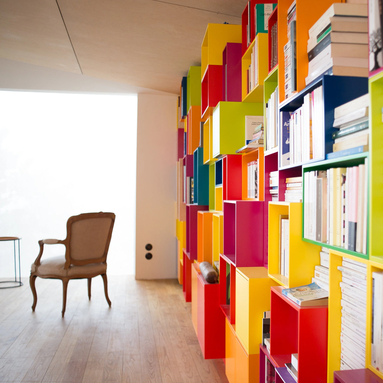 Großzügige Regalwand mit zahlreichen Modulen zur Bücheraufbewahrung, individuell geplant und farblich vielfältig gestaltet