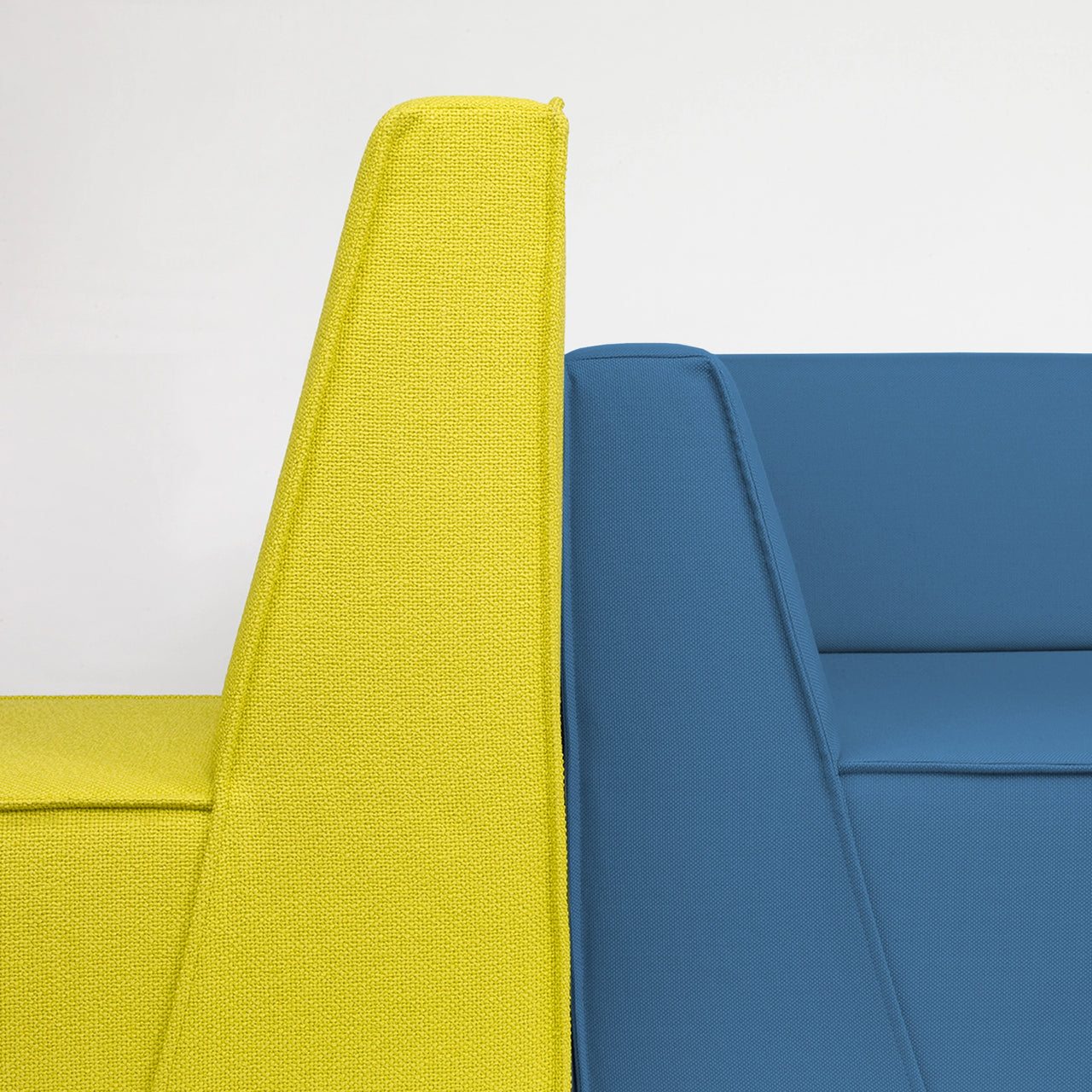 Detailaufnahme zweier Cubit Sofamodule in kräftigem Gelb und Blau im Showroom Delbrück, Rückenansicht betont die Formensprache und Stoffstruktur
