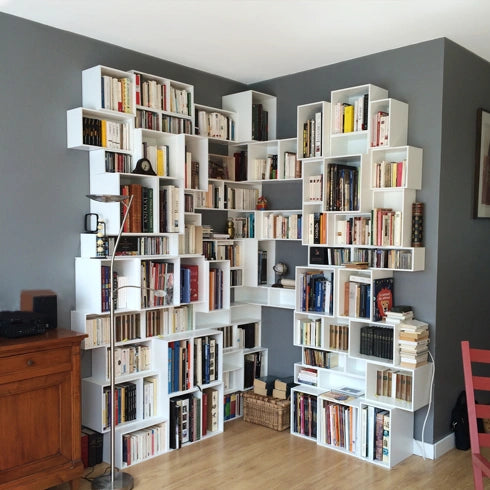 White Corner shelving, ideal for books, combined with a gray wall and wooden floor.