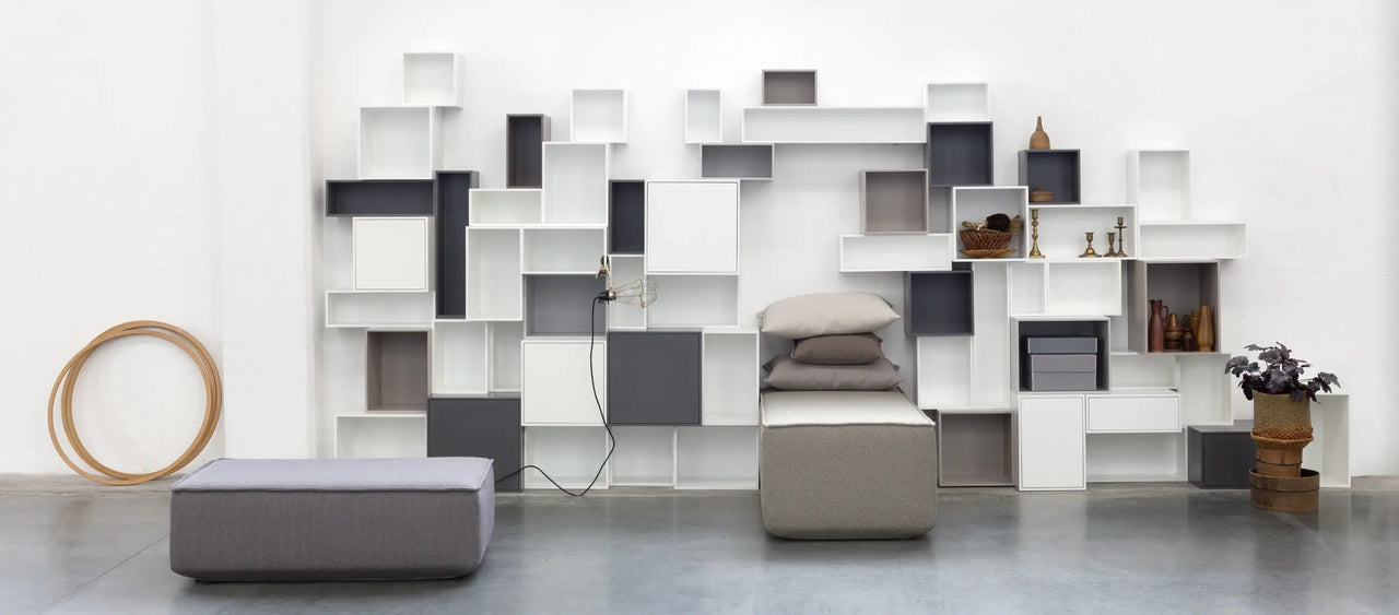 Système d'étagères modulaires Système d'étagères gris et blanc, avec des modules de canapé gris et des coussins.