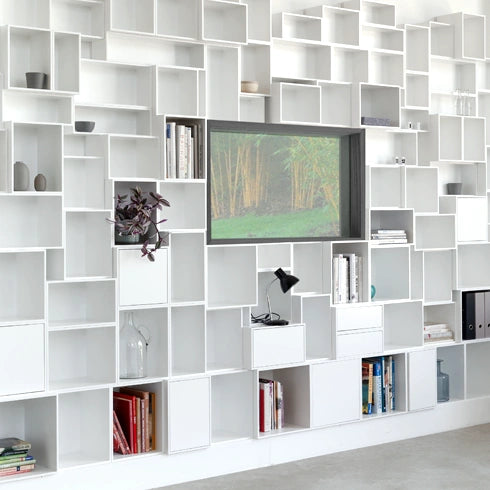 Shelves around a window, white and minimalist, combined with books and decorations.