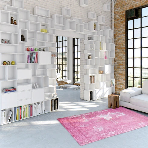 White Shelving system in a loft, combined with brick walls and large windows.
