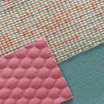 Verschiedene Stoffmuster für Sofas, darunter ein gepunkteter rosa Stoff, ein strukturierter türkisfarbener Stoff und ein bunt gemusterter Stoff mit Multicolor-Fäden – harmonische Kombination für individuelles Möbeldesign