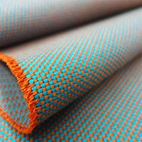 Stoffmuster Novum, gemustert in den Farben türkis und orange.